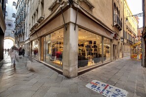 Un bâtiment d’angle doté de grandes fenêtres en verre à travers lesquelles on peut voir divers articles exposés.