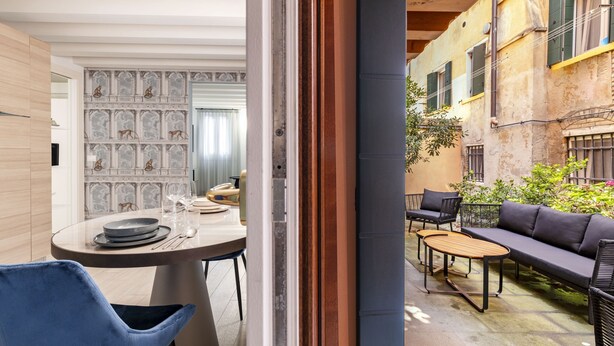 Un espace repas moderne avec une table ronde, des chaises bleues et un canapé.