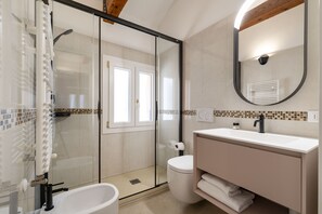 A modern bathroom with a glass shower enclosure, a white sink, and a large mirror. - The Red Sunset by Wonderful Italy (Venice)