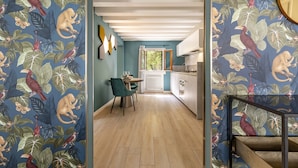 A narrow hallway with a dining area, kitchen, and staircase. - The Green Jungle by Wonderful Italy (Venice)