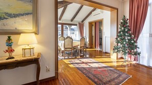 A room with a wooden floor, a dining table with chairs, a Christmas tree, and a painting on the wall. - Palazzo Gradenigo by Wonderful Italy (Venice)