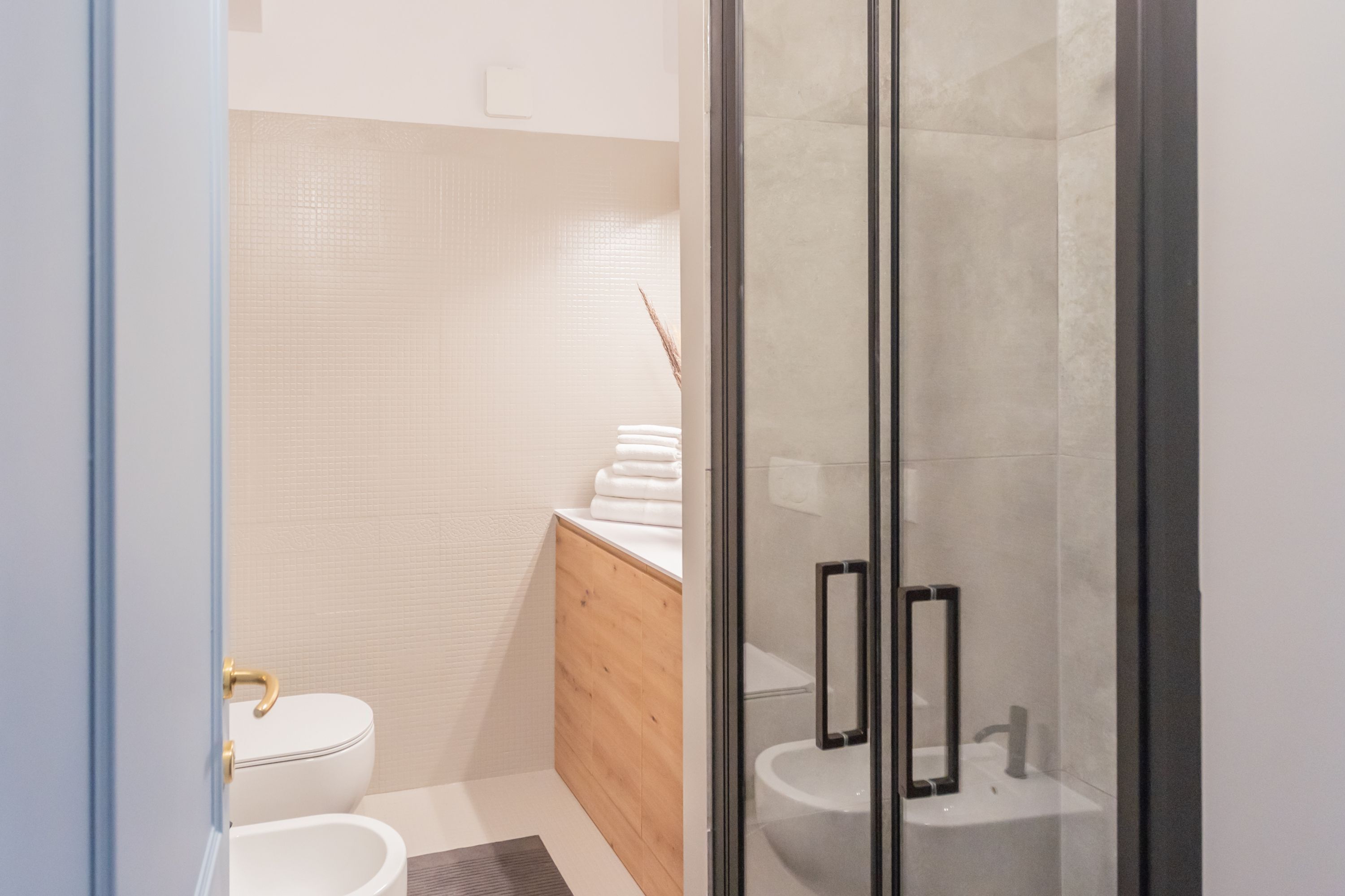 A modern bathroom with a toilet, sink, and shower area.