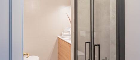 A modern bathroom with a toilet, sink, and shower area.