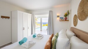 A hotel room with a bed, a wardrobe, a view of the pool, and decorative wall art. - Caribbean Delight Villa With Stunning Pool View (St. Marie)