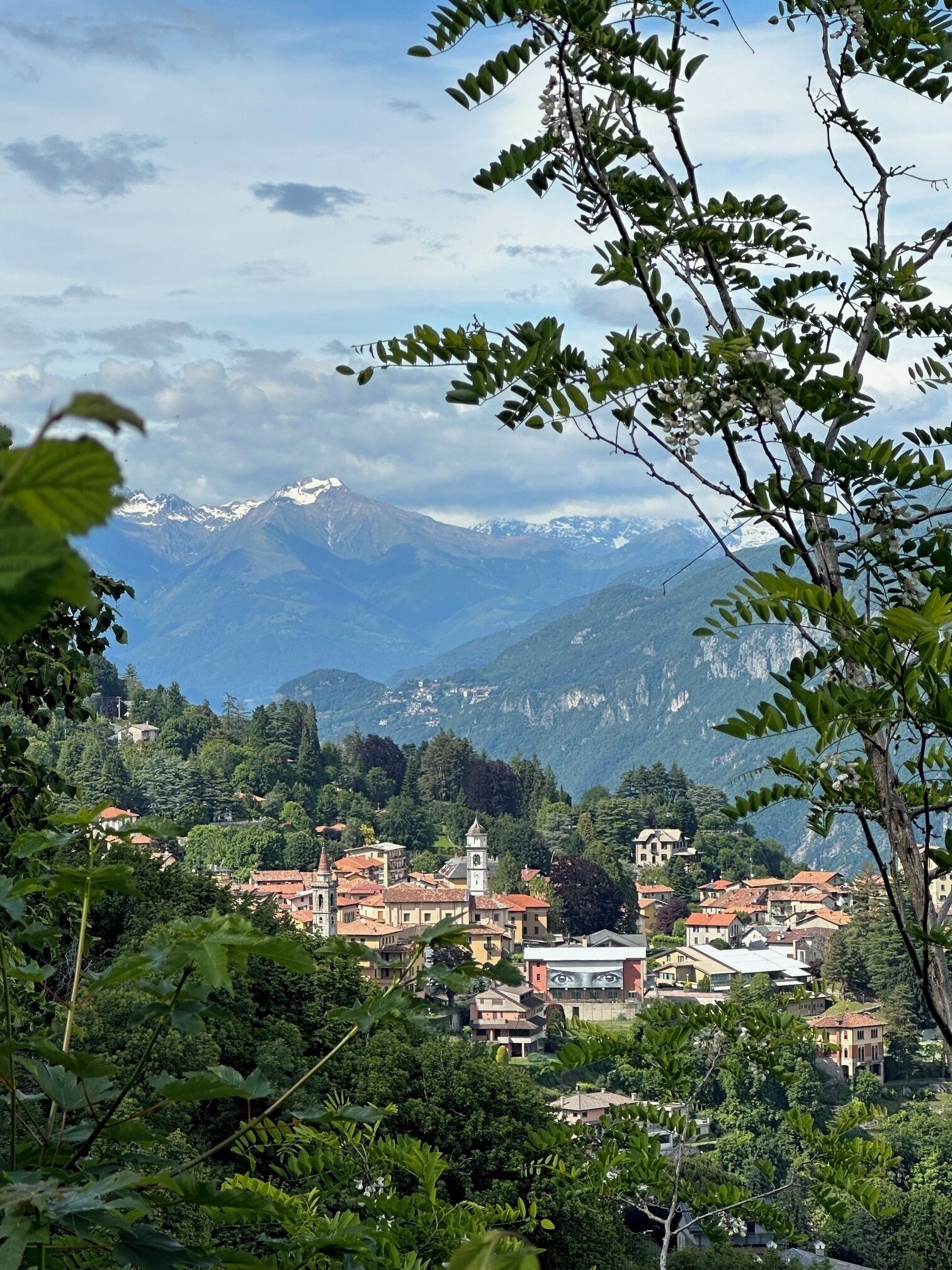 A mountainous town with traditional architecture, a prominent church, and a view of snow-capped peaks.