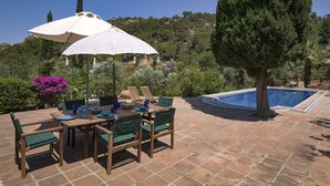 An outdoor patio with a pool, wooden table, chairs, and umbrellas. - Ottoman Villa - Five Bedroom Villa, Sleeps 10 (Yalıkavak Mahallesi)