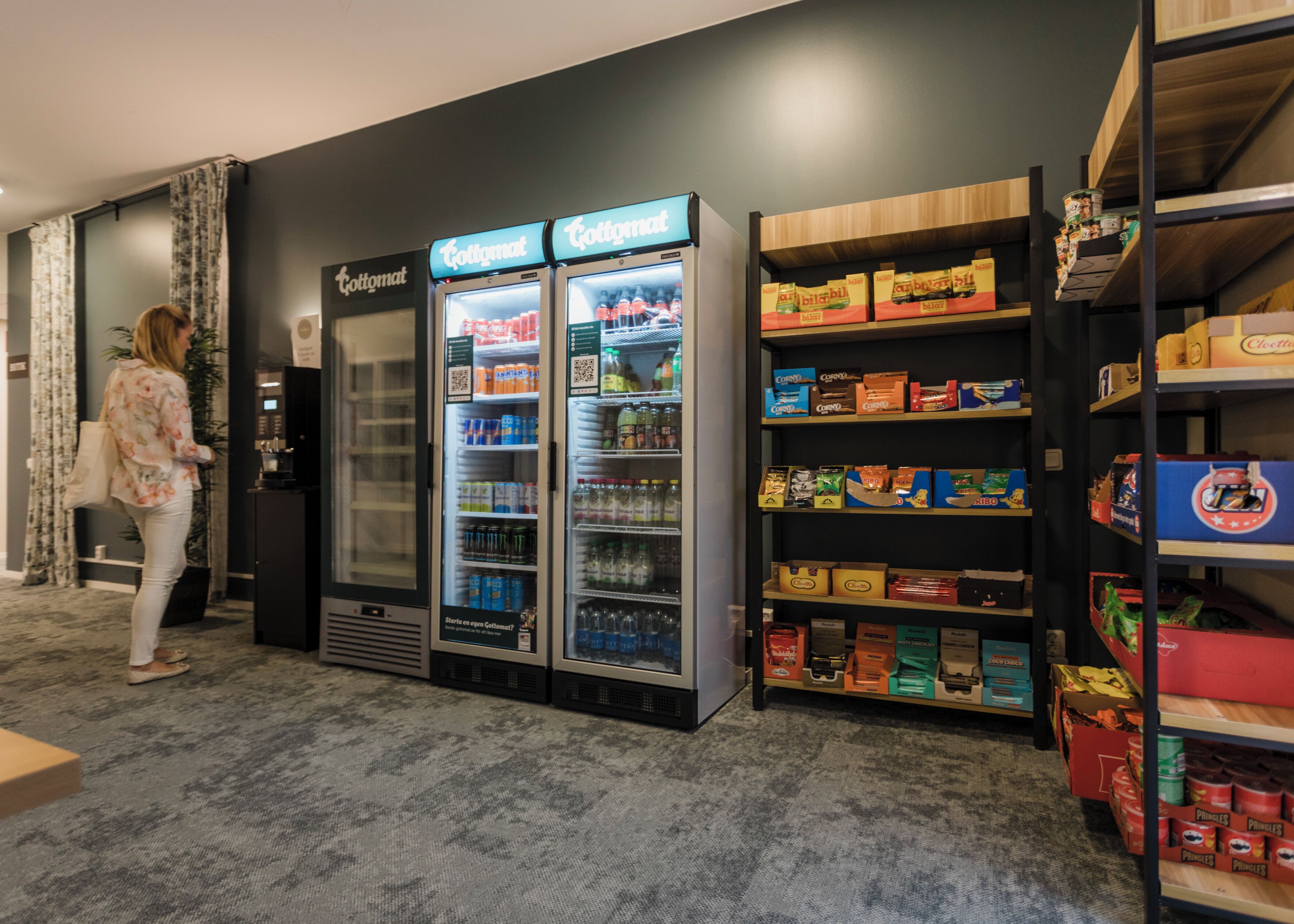Een automaatruimte met Cotomat koelkasten en schappen vol snacks en drankjes.