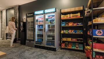 Een automaatruimte met Cotomat koelkasten en schappen vol snacks en drankjes.
