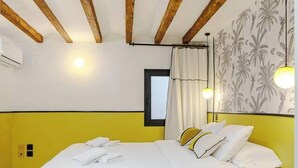 A bedroom with a bed, yellow walls, a window, and a wall-mounted light fixture. - Apt Charme Exceptionnel Alicante (Alacant)