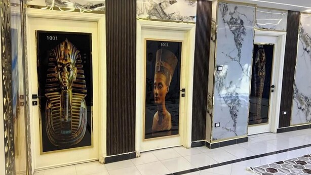 A hallway with doors numbered 1001 to 1003, each with a unique artwork. - Miracle Pyramids View Hotel (Giza)