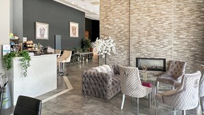 A modern hotel lobby with a reception desk, seating area, and a decorative wall. - 2 bedroom accommodation in St Andrews (St Andrews)