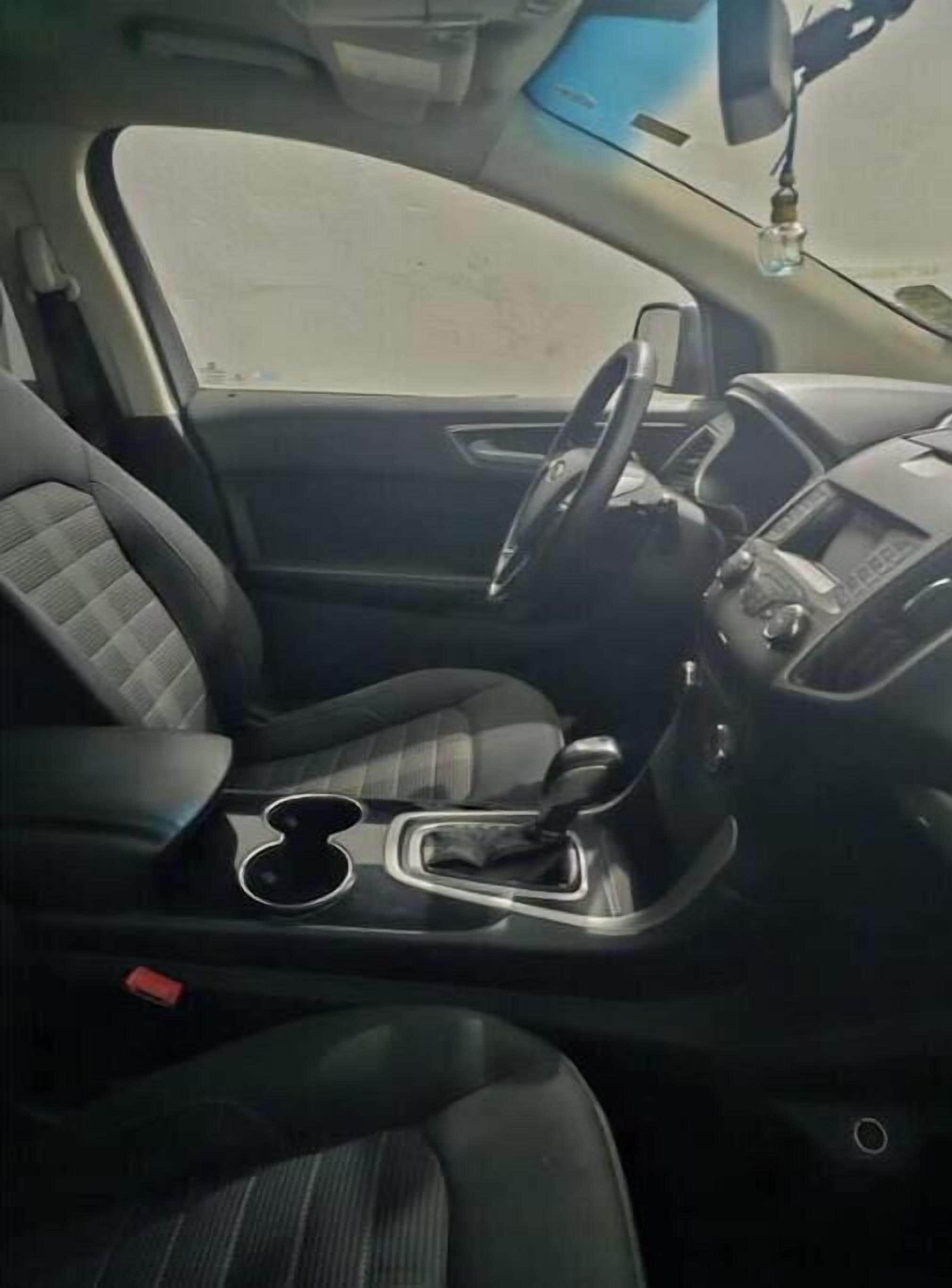 Een auto interieur met stuurwiel, dashboard en middenconsole.