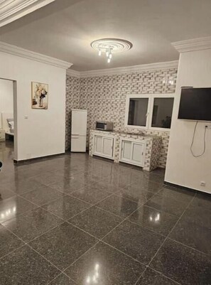 Modern kitchen with a central island, white cabinetry, and a brick-patterned backsplash.