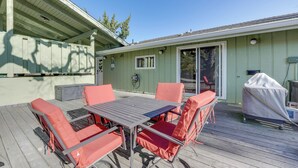 A patio with a table and chairs, a covered grill, and a sliding glass door. - Medford Vacation Rental w/ En-Suite Bathrooms! (Medford)