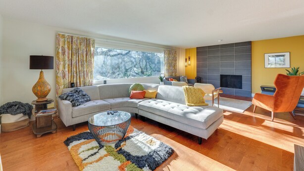 A modern living room with a sectional sofa, a round coffee table, and a fireplace. - Medford Vacation Rental w/ En-Suite Bathrooms! (Medford)