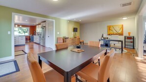 A spacious dining area with a large table and chairs, a kitchen in the background, and a modern art piece on the wall. - Medford Vacation Rental w/ En-Suite Bathrooms! (Medford)