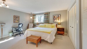 A bedroom with a bed, desk, chair, and a small wooden bench. - Medford Vacation Rental w/ En-Suite Bathrooms! (Medford)
