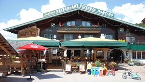 A wooden building with a sign reading "Jagdhaus Restaurant Pizzeria Dancing."