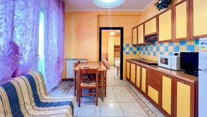 Un espacio habitable compacto con comedor, kitchenette y sofá.