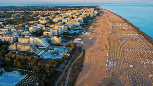 Vista aérea de una ciudad costera con una amplia zona de playa y densa edificación urbana.