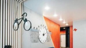 Ein modernes Interieur mit einem Holztisch, einem blauen Sofa und einem an der Wand befestigten Fahrrad.