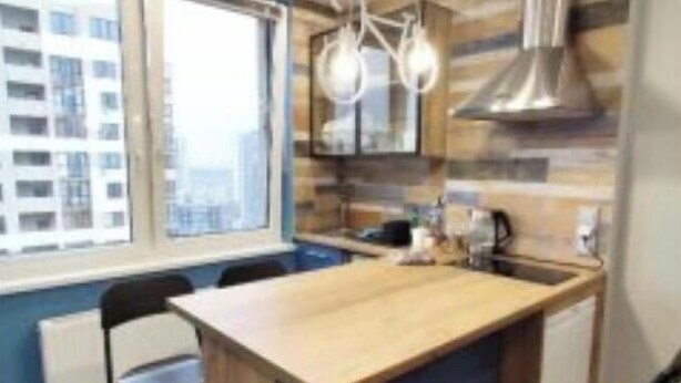 Una cucina moderna con isola centrale, una finestra e vista su un edificio.