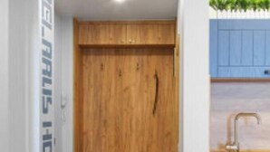 Een hal met een houten garderobe, een blauwe kast en een kamerbreed tapijt.