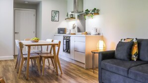 Un espace de vie compact comprenant un coin cuisine, un coin repas et un canapé.