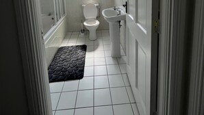 Een badkamer met toilet, wastafel en douche.