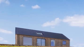 Un bâtiment moderne en bois, doté de grandes fenêtres et d’un toit en pente.
