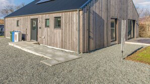 Un edificio de madera con techo inclinado y paneles solares.