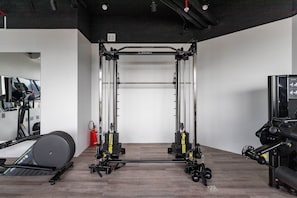 A gym with a pull-up bar, weight bench, and exercise equipment. - (1402) 2 Suítes, Vista para o Mar e Cristo (Rio de Janeiro)