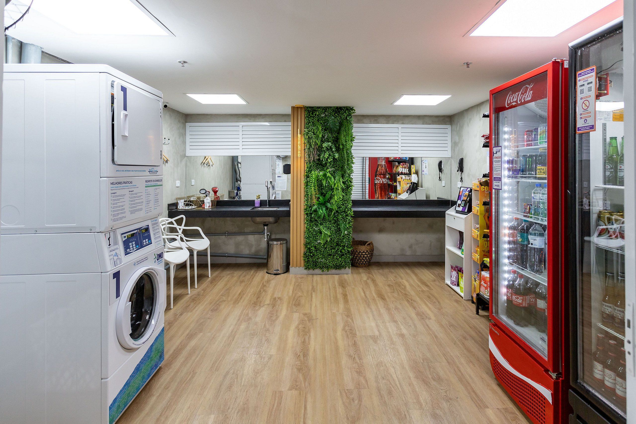 Un área de lavandería con lavadora, lavamanos y refrigerador Coca-Cola.
