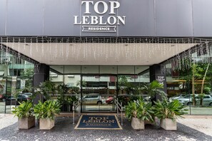 The entrance of Top Leblon Residence with a clear view of the entrance, potted plants, and the building's signage. - (1402) 2 Suítes, Vista para o Mar e Cristo (Rio de Janeiro)