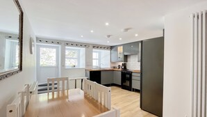 A modern kitchen with a dining area, wooden flooring, and white cabinetry. - 3 bedroom accommodation in Coldstream, near Kelso (Coldstream, near Kelso)