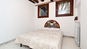 A bedroom with a bed, two windows, and a radiator. - San Polo Apartment by Ca-sa Check (Venice)