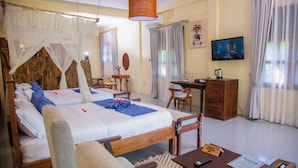 A hotel room with two beds, a desk, a chair, a TV, and a small cabinet.