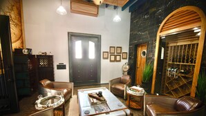 A room with leather chairs, a coffee table, and a large wooden door. - Casa 1880 - Adults Only (La Paz)