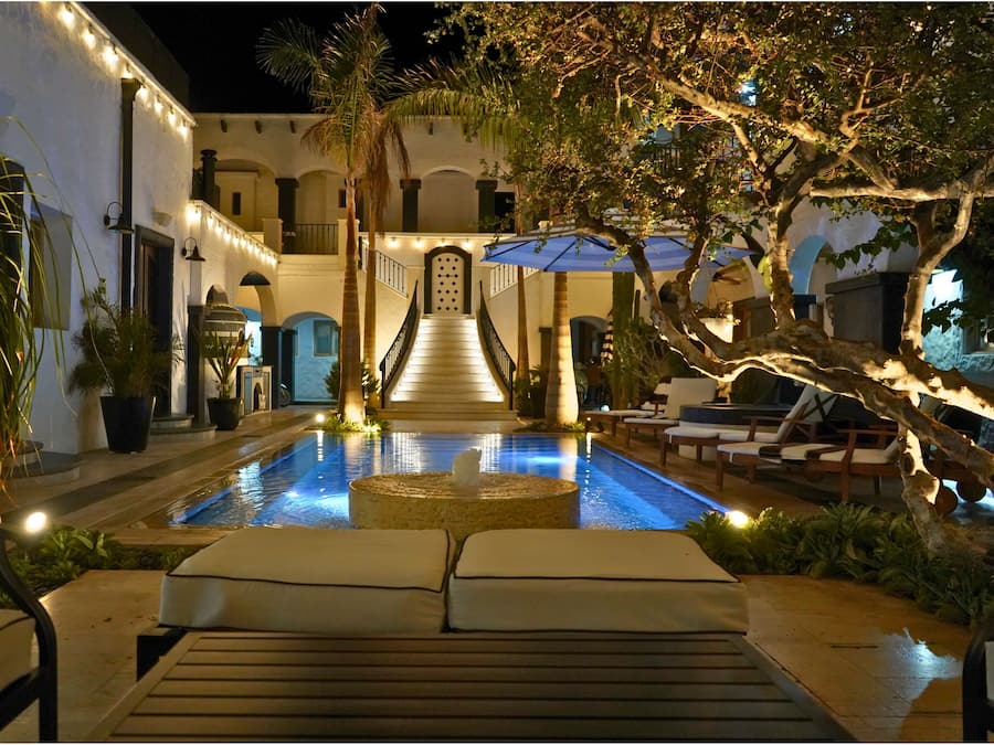 Una piscina al aire libre, sombrillas, sillones reclinables de piscina