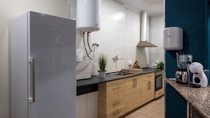 A kitchen with a refrigerator, sink, stove, and various appliances. - SOM HOSTEL BOUTIQUE  (Valencia)