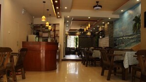 A restaurant with wooden furniture and pendant lighting. - Qionghai Bojingchuanxi Hotel (Qionghai)