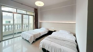 A modern hotel room with two beds, large windows, and a balcony. - Qionghai Bojingchuanxi Hotel (Qionghai)