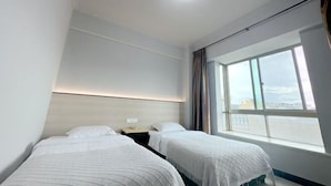A hotel room with two beds, a large window, and a ceiling light. - Qionghai Bojingchuanxi Hotel (Qionghai)