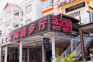 A building with a sign that reads 'Dragon's Home' and 'Seafood Restaurant.' - Caixia Inn (Shenzhen Xiyong Dapeng Branch) (Shenzhen)