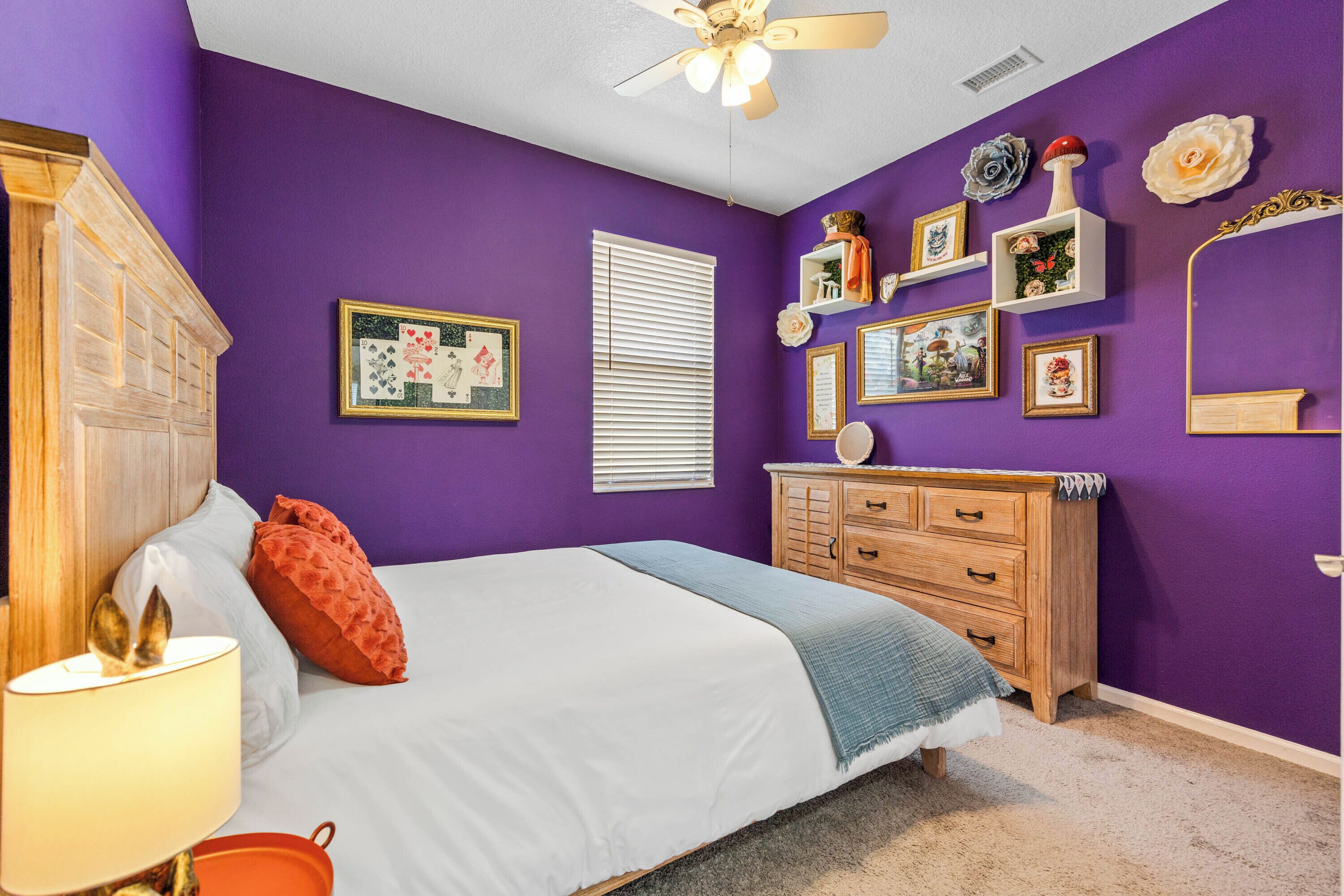 Un dormitorio con cama, cómoda y adornos en la pared.