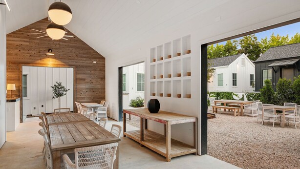 Un intérieur moderne avec un coin repas en bois, des murs blancs et une vue sur l’extérieur.