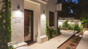 L’extérieur de l’hôtel Whitetail Court présente une façade épurée et moderne, avec une enseigne indiquant qu’il est situé au 211, rue Austin Ouest.