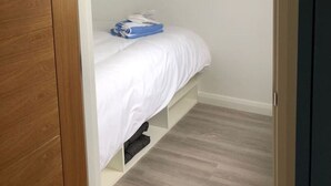Ein Schlafzimmer mit einem Bett, einem Holzschrank und einer weißen Decke.