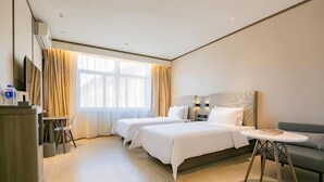 A hotel room with two beds, a desk, a chair, a sofa, and a small table. - HanTing Hotel (Yan'an University Yangjialing) (Yan'an)