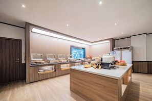 A modern kitchen with a central island, built-in appliances, and a large window.